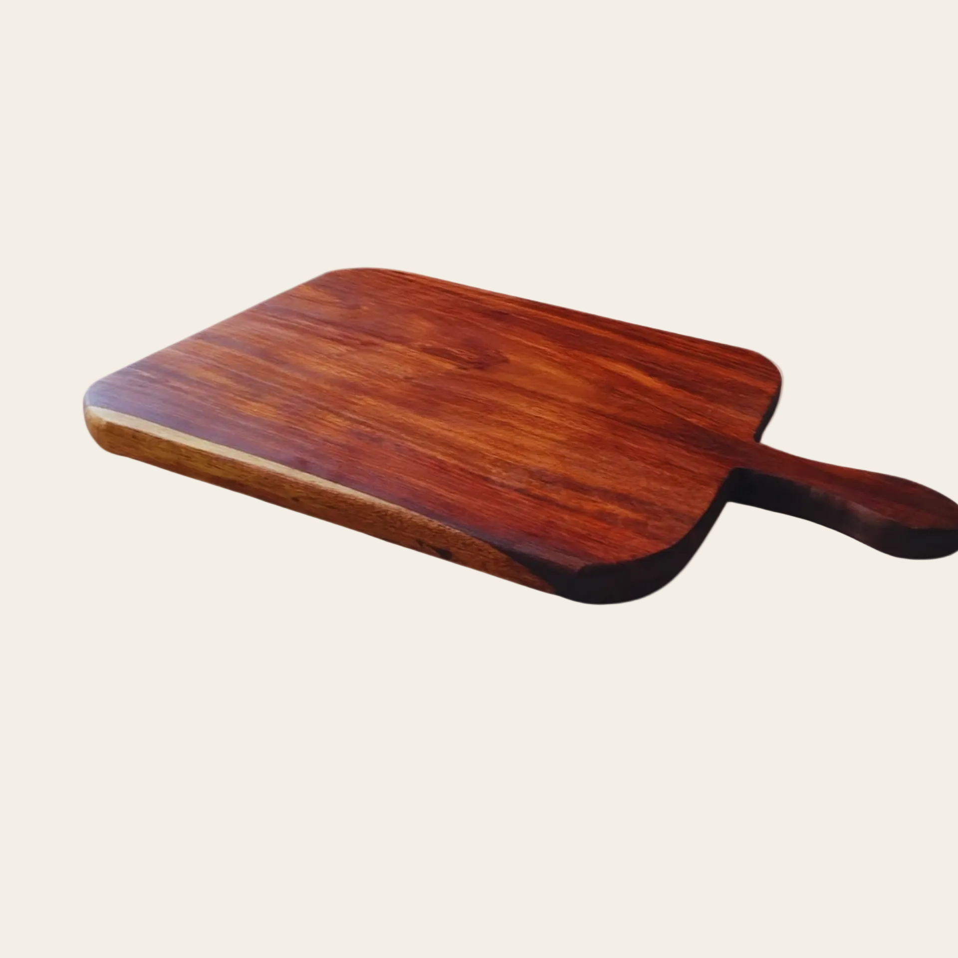 A rectangular wooden serving board with rounded corners and a single handle, shown at an angle on a plain light beige background.